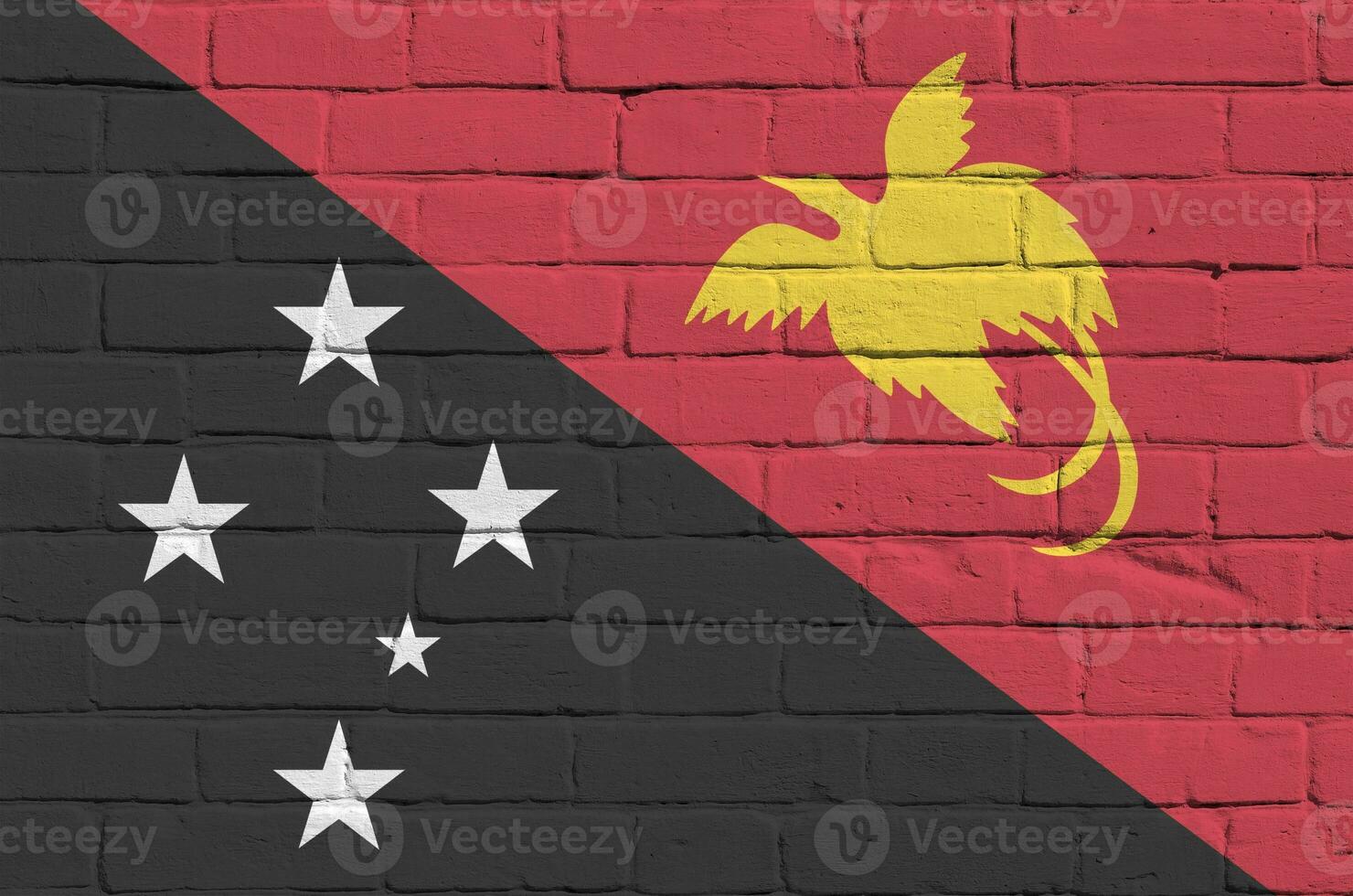 papua Novo Guiné bandeira retratado dentro pintura cores em velho tijolo muro. texturizado bandeira em grande tijolo parede alvenaria fundo foto