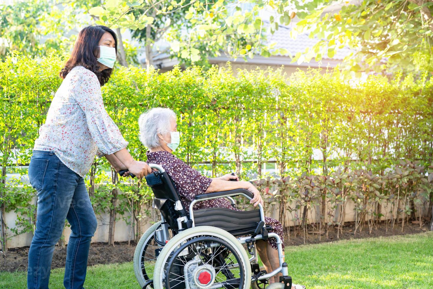médico, ajuda e cuidados, paciente asiática idosa sentada na cadeira de rodas foto