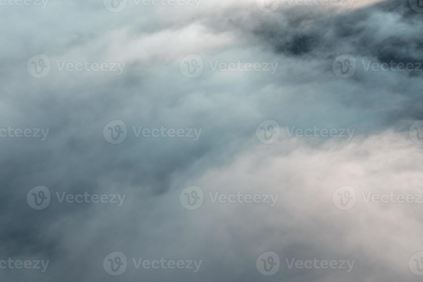 nevoeiro matinal nas montanhas vindo de cima foto