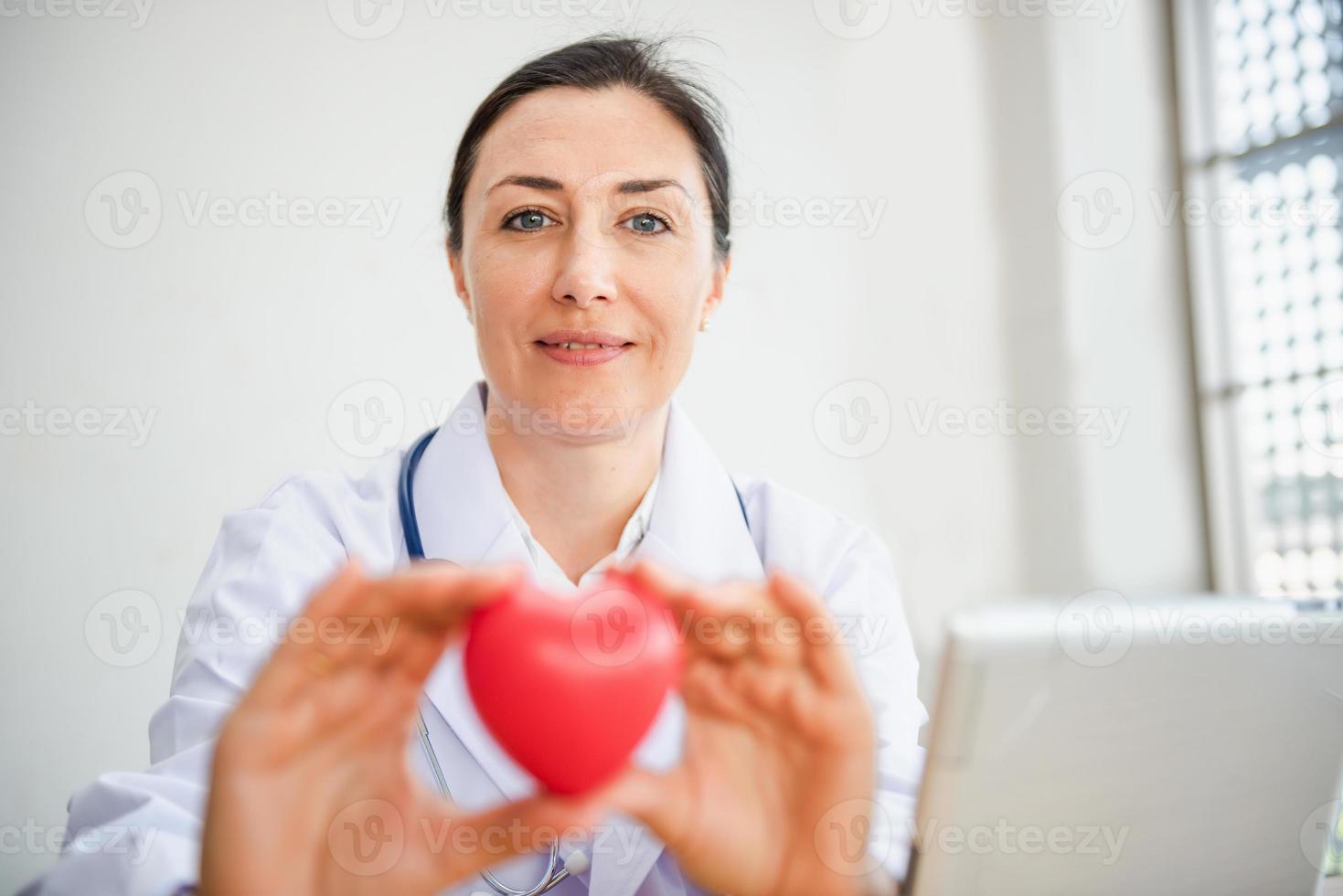 médico cardiologista médico está segurando um coração vermelho para dar ao paciente foto