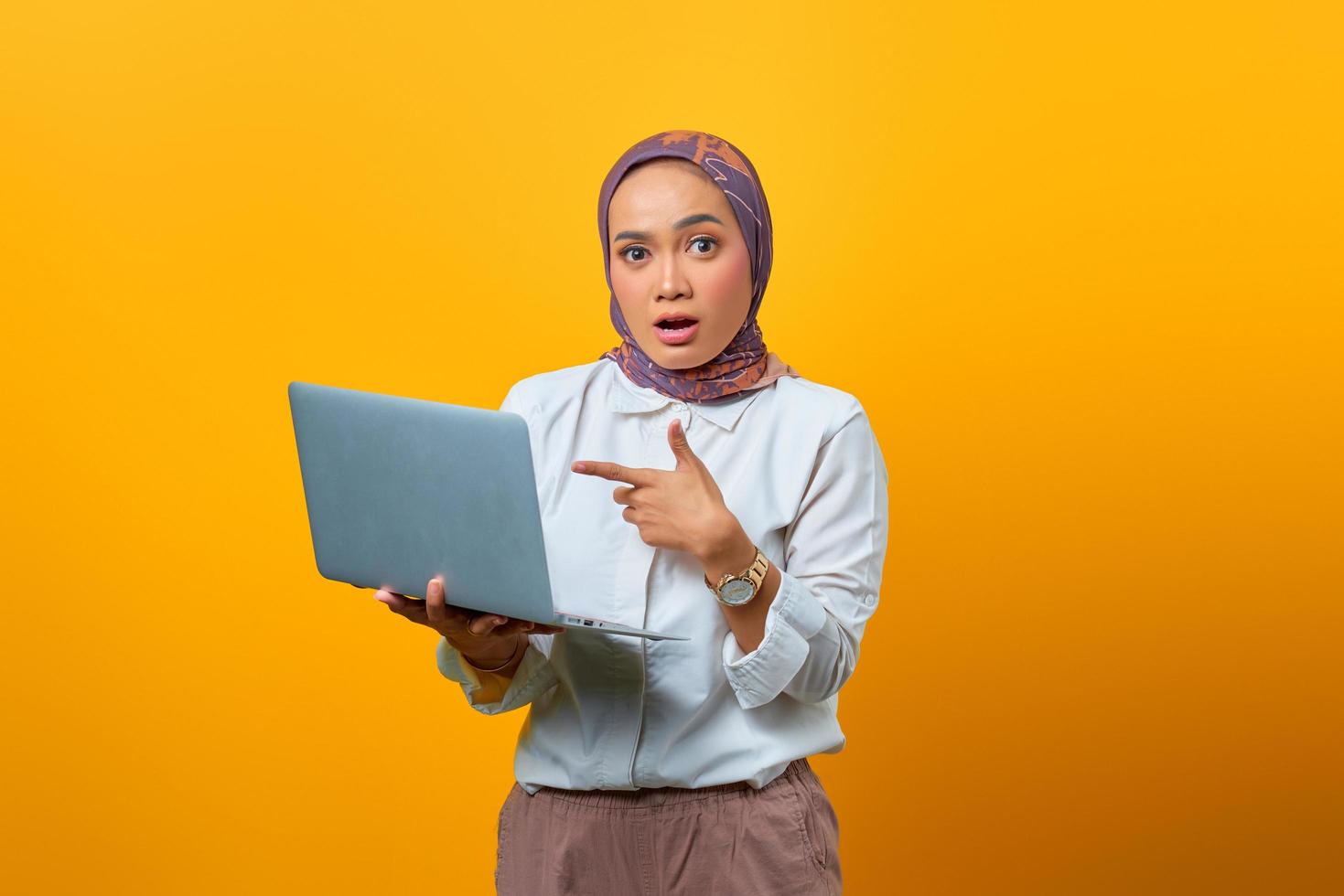 retrato de uma mulher asiática surpresa segurando um laptop foto