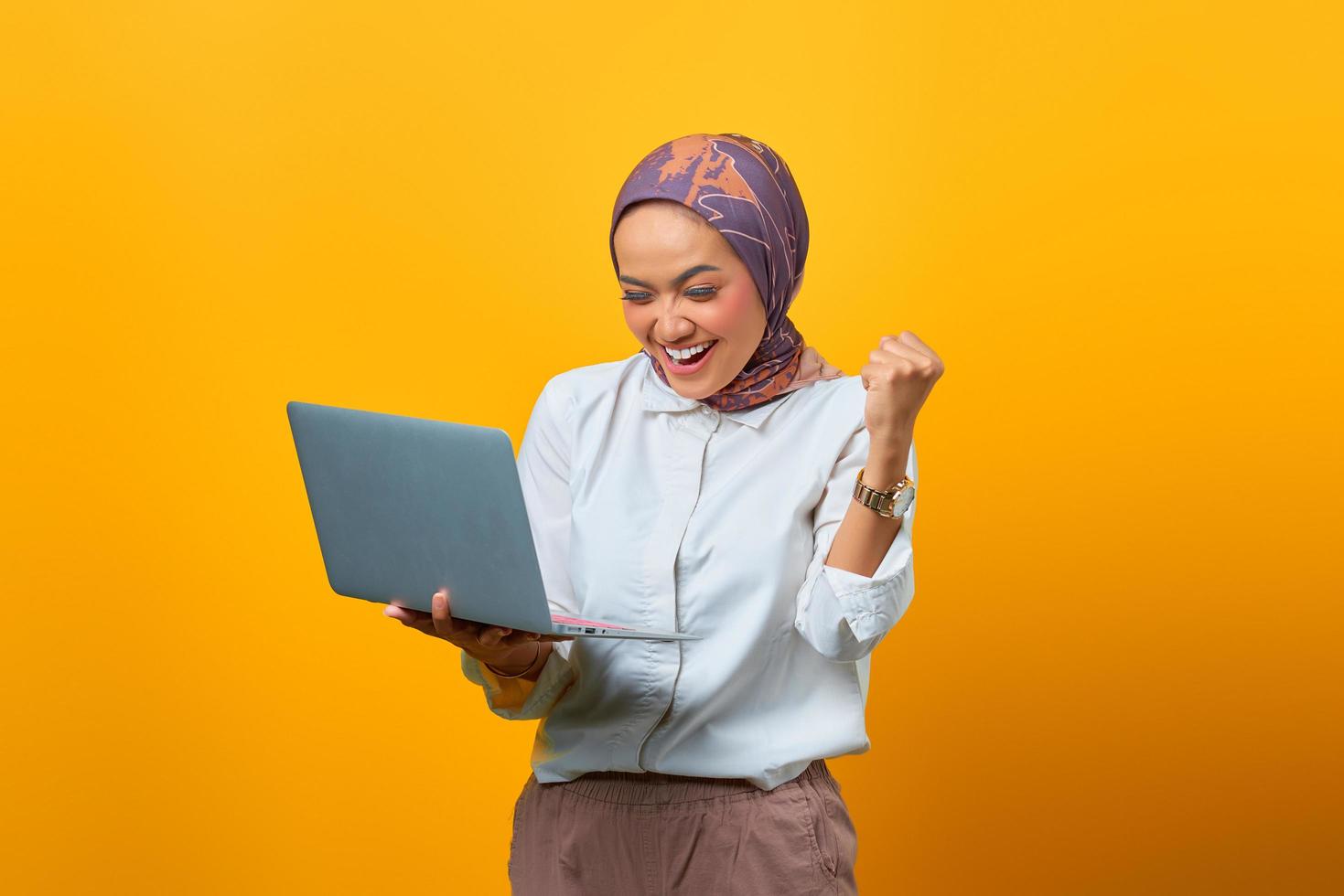 retrato de uma mulher asiática animada segurando um laptop foto