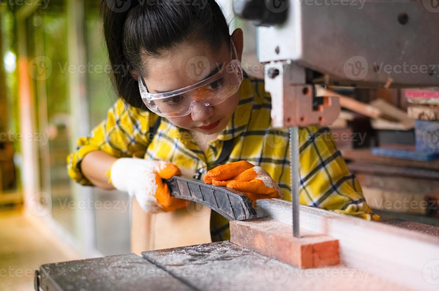 mulher trabalhando cortando madeira com serras de fita ferramentas elétricas foto