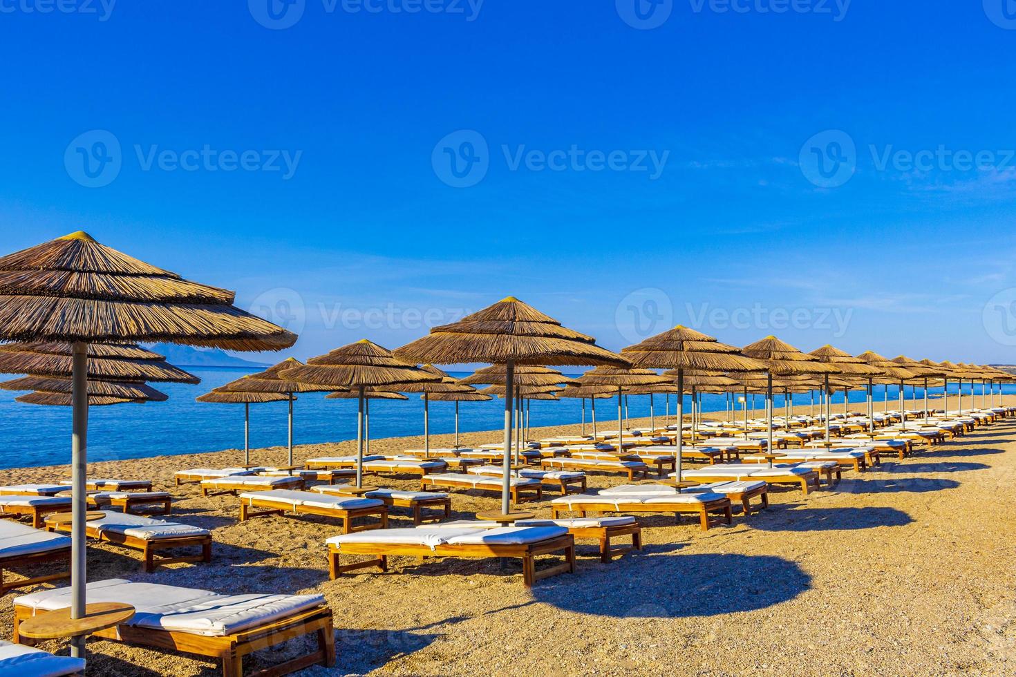 espreguiçadeiras e guarda-sóis na praia de kos island greece. foto