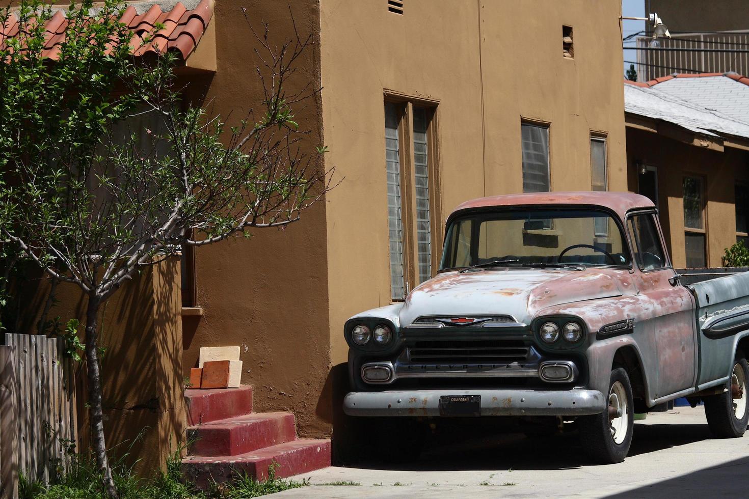 um carro velho estacionado em frente a uma casa americana foto