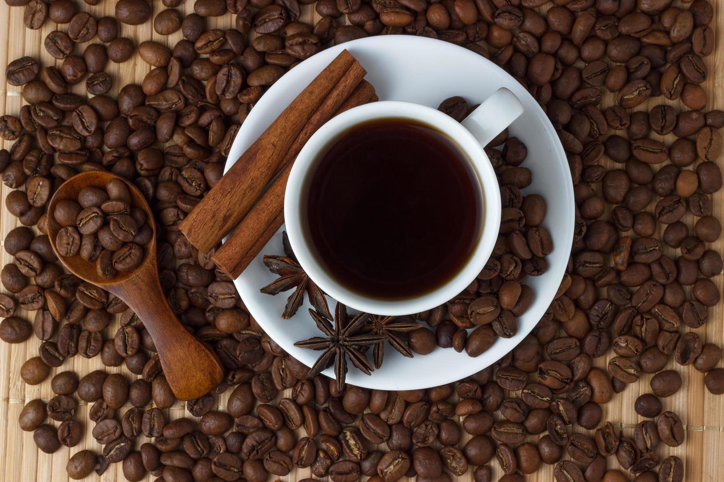 café em uma xícara com paus de canela e erva-doce foto