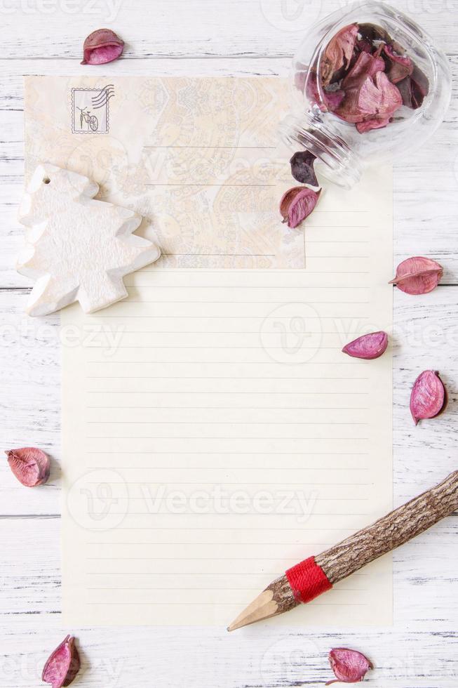 papel com pétalas, lápis e árvore foto