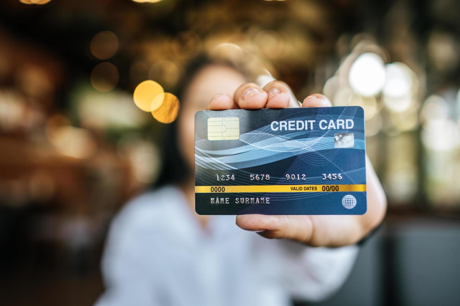 mulher segurando cartão de crédito em restaurante foto