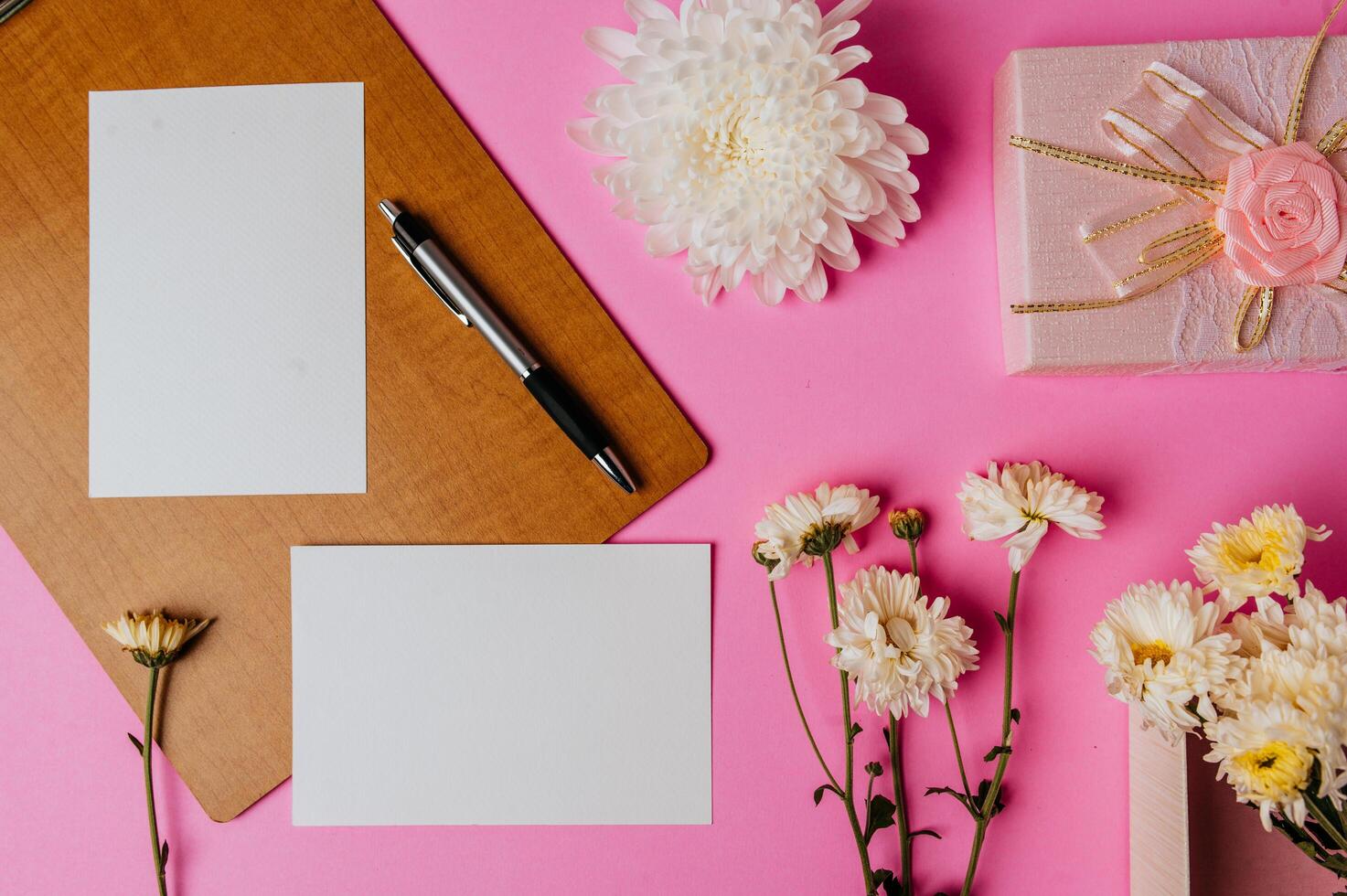 caixa de presente rosa, flor, caneta, placa de madeira e cartão em branco rosa foto