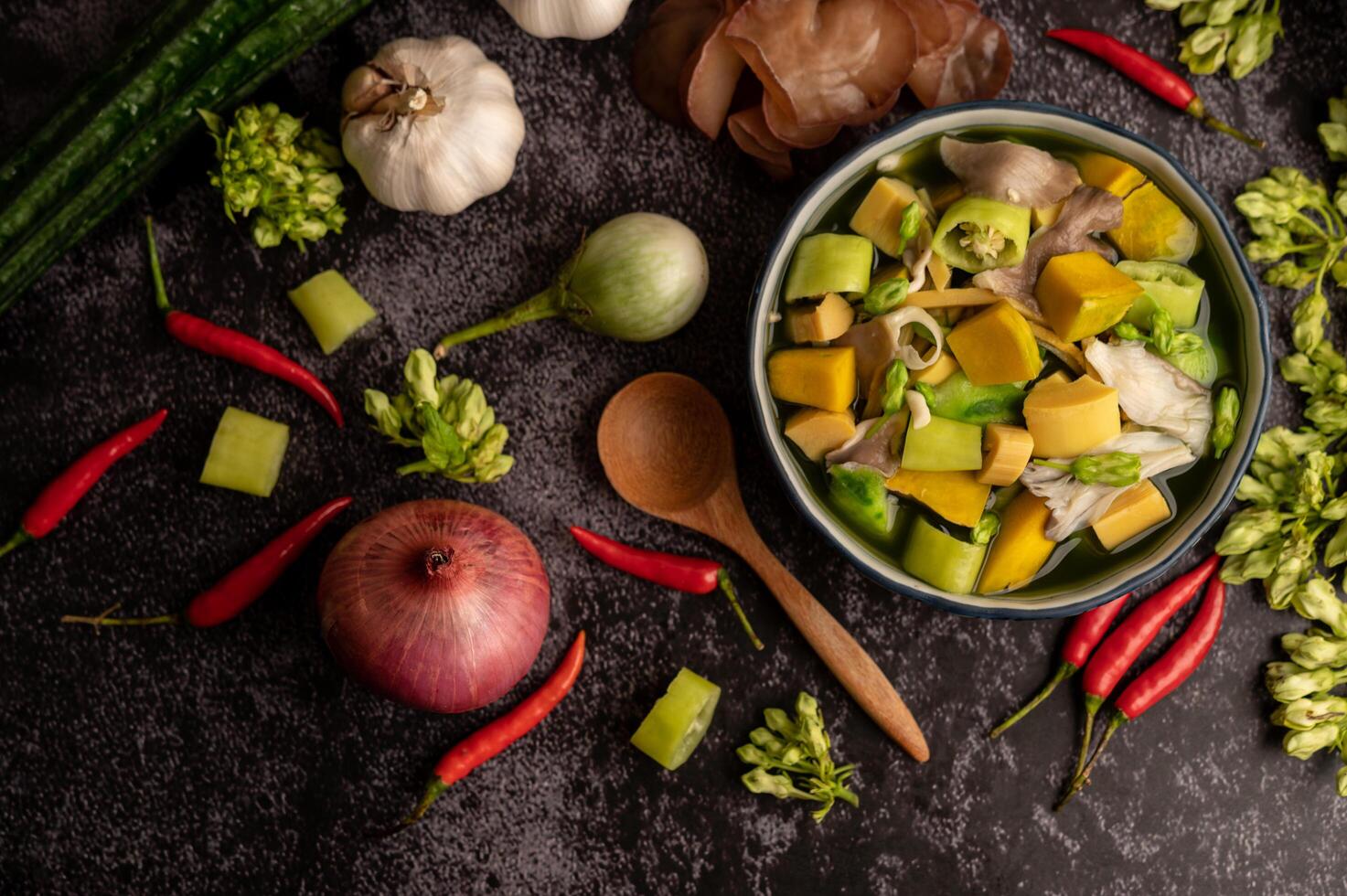 kaeng liang em uma tigela com especiarias no chão de cimento preto. foto