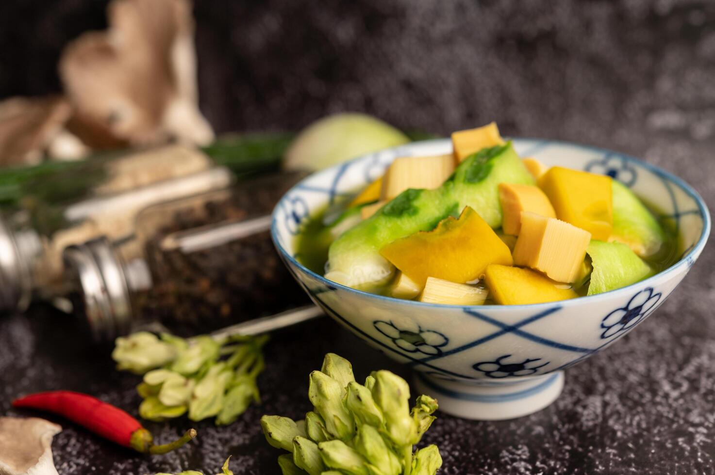 kaeng liang em uma tigela com especiarias no chão de cimento preto. foto