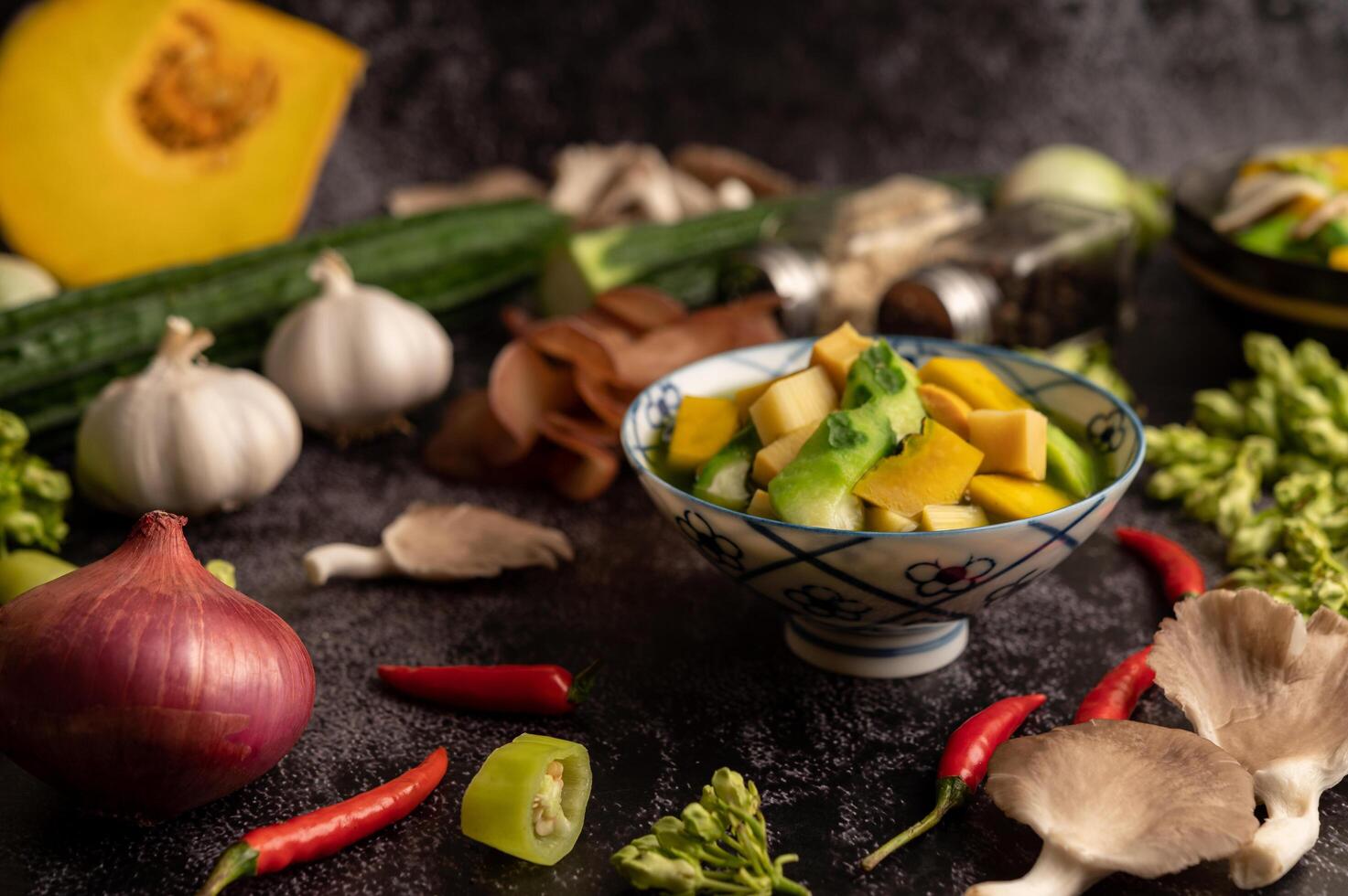 kaeng liang em uma tigela com especiarias no chão de cimento preto. foto