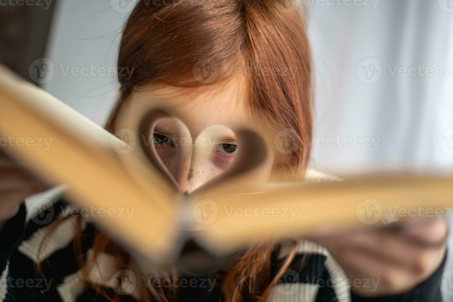 uma menina é segurando uma livro. em forma de coração Páginas. leitura, sabendo, Aprendendo foto