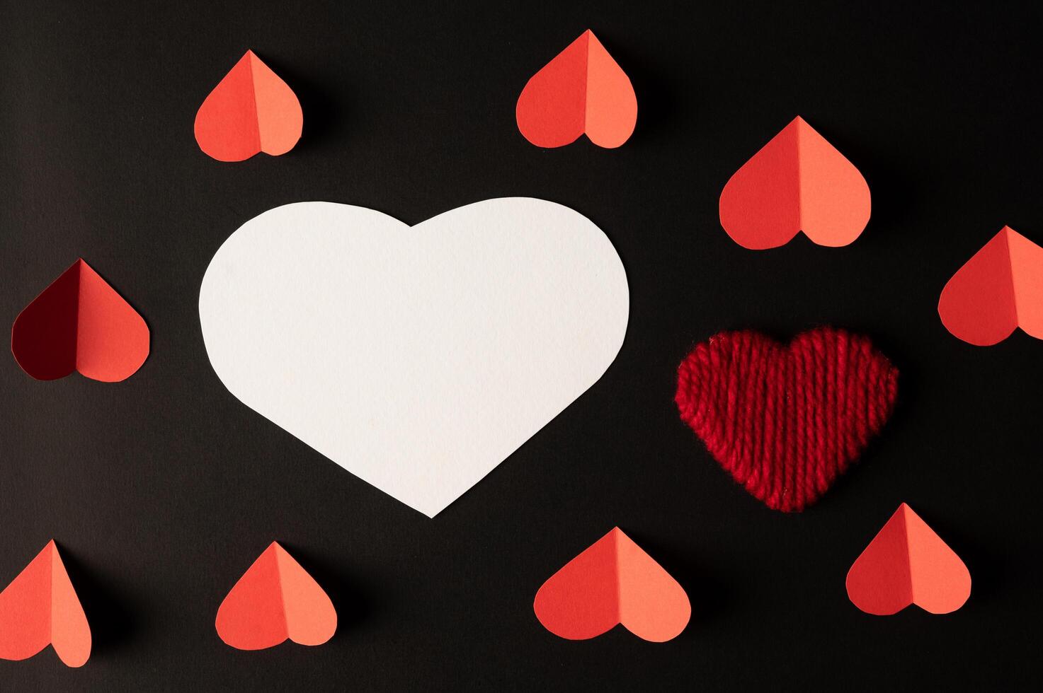 corações brancos e corações vermelhos feitos de papel são colocados foto