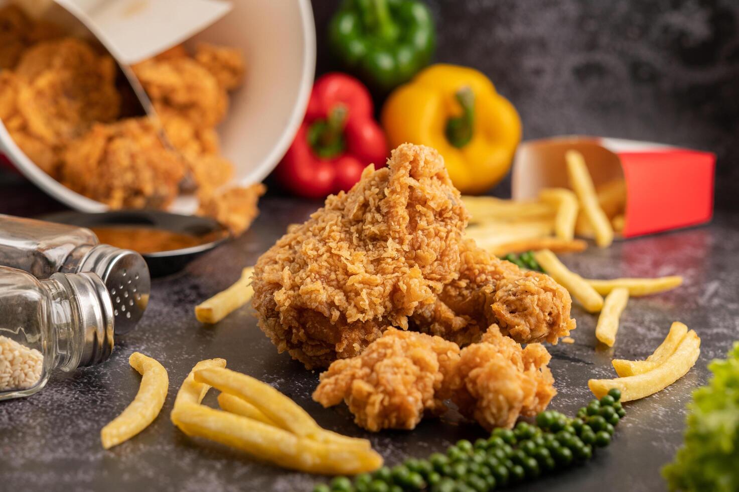 frango frito e batatas fritas no chão de cimento preto. foto