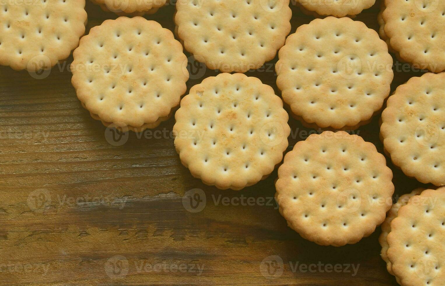 um biscoito redondo com recheio de coco está em grandes quantidades em uma superfície de madeira marrom. foto de guloseimas comestíveis em um fundo de madeira com espaço de cópia