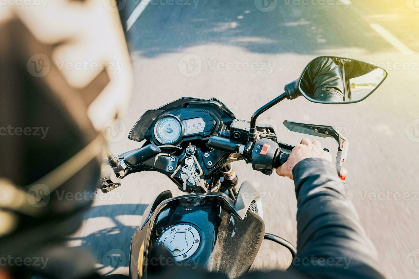 fechar acima do motociclista dirigindo dele moto em a rua. Visão do mãos do motociclista dirigindo dele moto foto