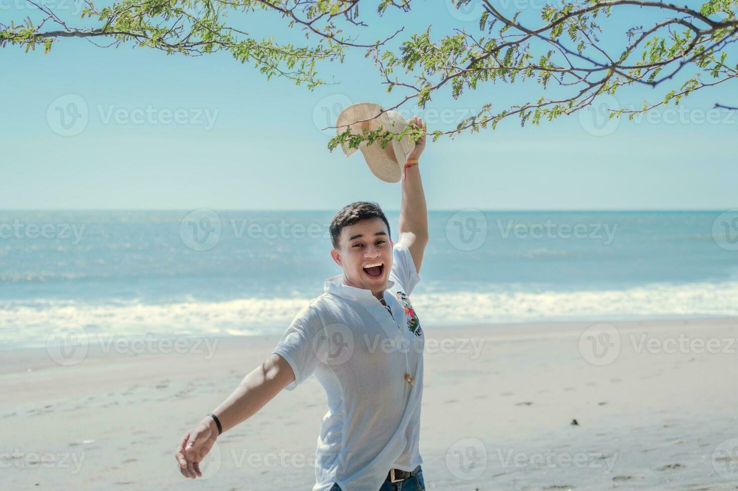 feliz bonito homem em período de férias ao ar livre, feliz latim jovem homem em a praia, turista viagem conceito foto