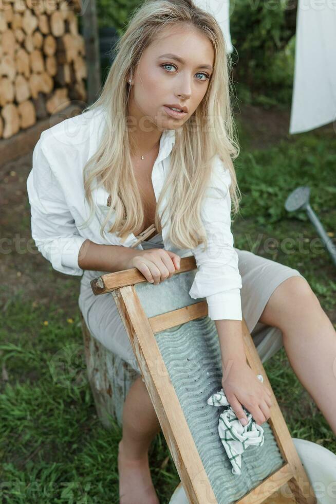 lavanderia dia. uma mulher trava linho e toalhas em uma árvore dentro a pátio do uma Vila casa. foto