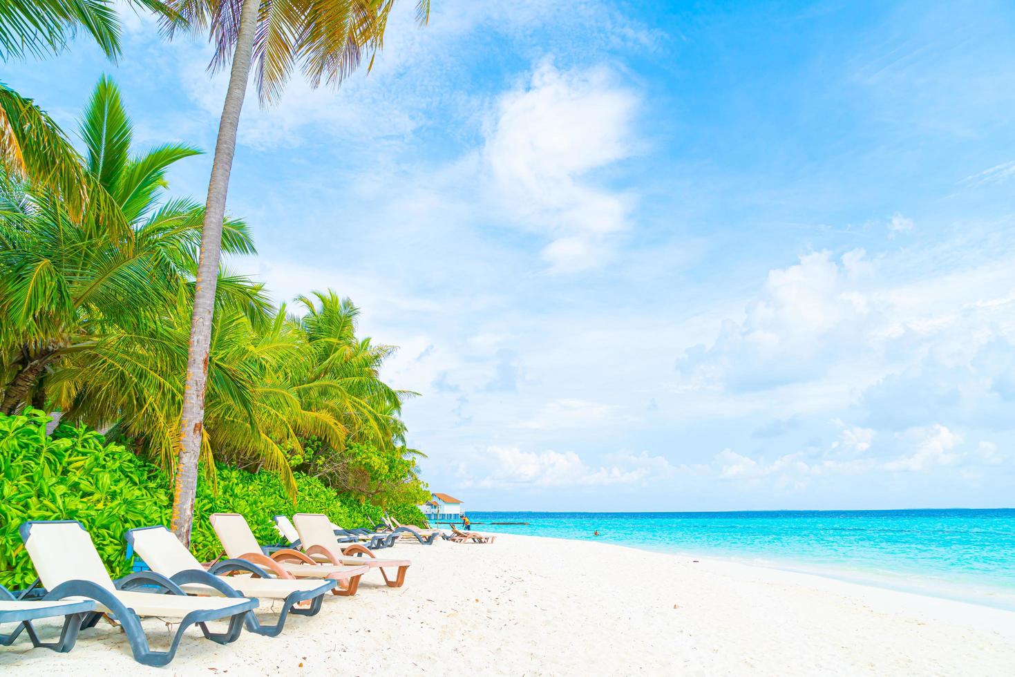 cadeira de praia com ilha tropical resort das Maldivas e mar foto