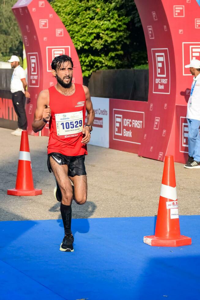 Novo Délhi, Índia - Outubro 15 2023 - vedanta Délhi metade maratona raça depois de cobiçado dentro que maratona participantes sobre para Cruz a terminar linha, Délhi metade maratona 2023 foto