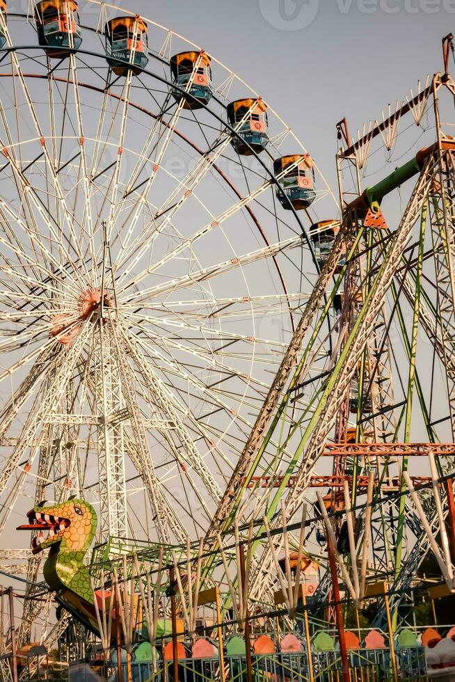 fechar-se do multicolorido gigante roda durante dussehra mela dentro Délhi, Índia. inferior Visão do gigante roda balanço. roda gigante com colorida cabines durante dia tempo. foto