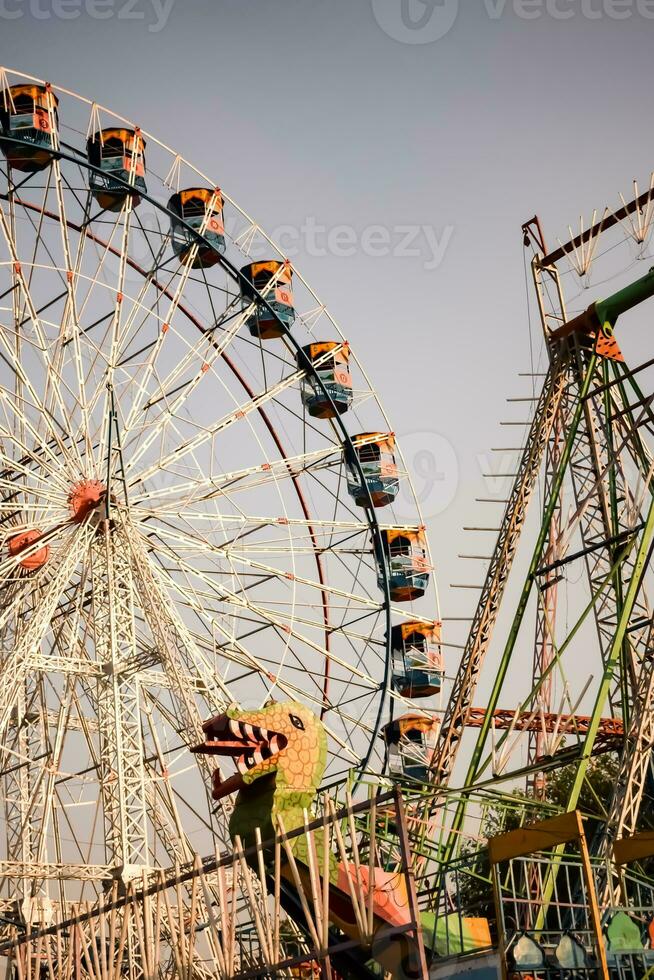 fechar-se do multicolorido gigante roda durante dussehra mela dentro Délhi, Índia. inferior Visão do gigante roda balanço. roda gigante com colorida cabines durante dia tempo. foto