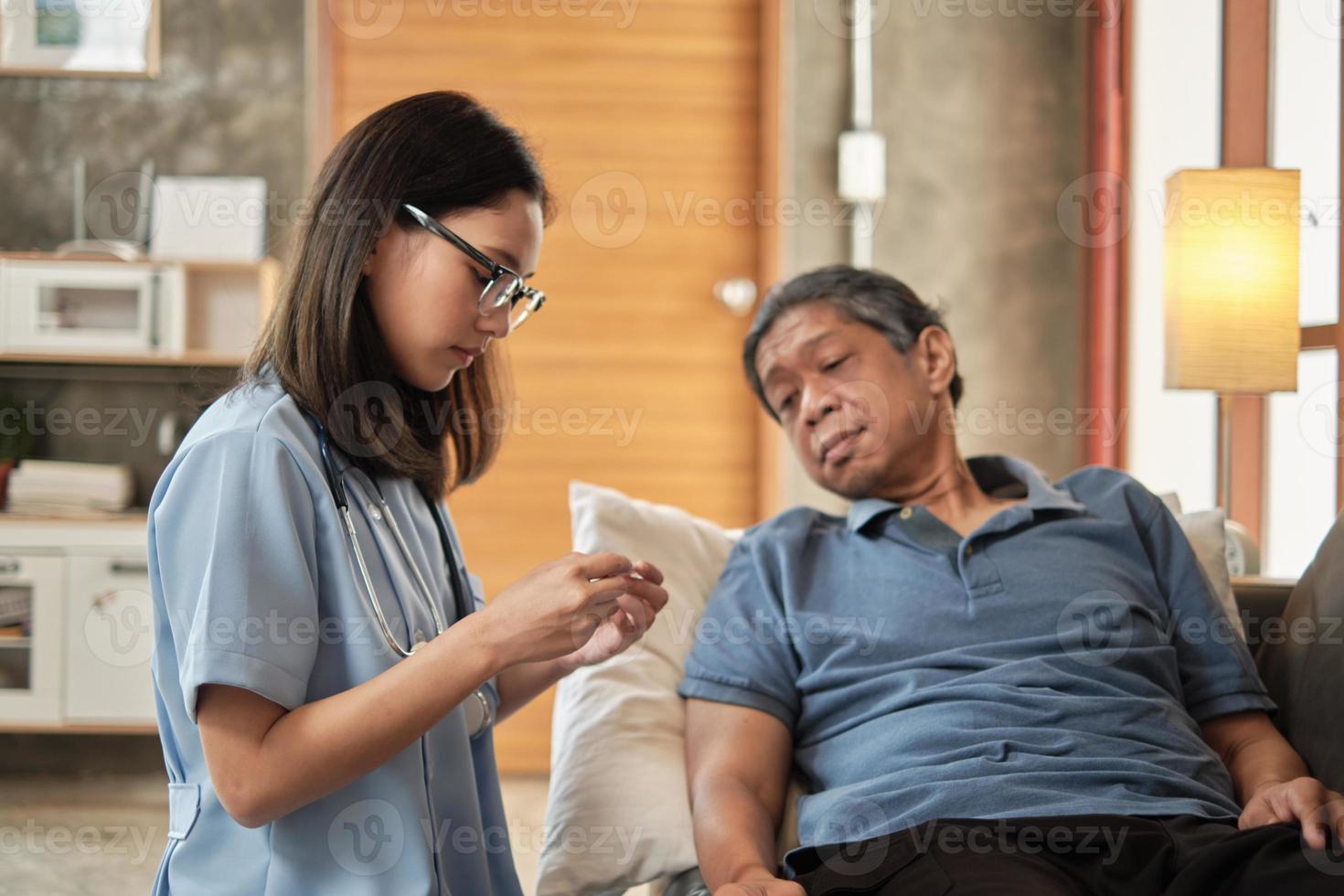 médica, verificando a saúde de paciente idoso asiático do sexo masculino em casa. foto