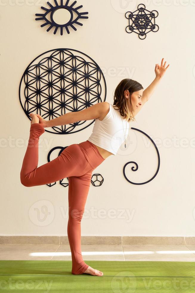 jovem praticando asanas de ioga com roupas esportivas foto