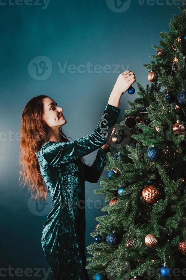 mulher sorridente atraente decorando árvore de natal foto