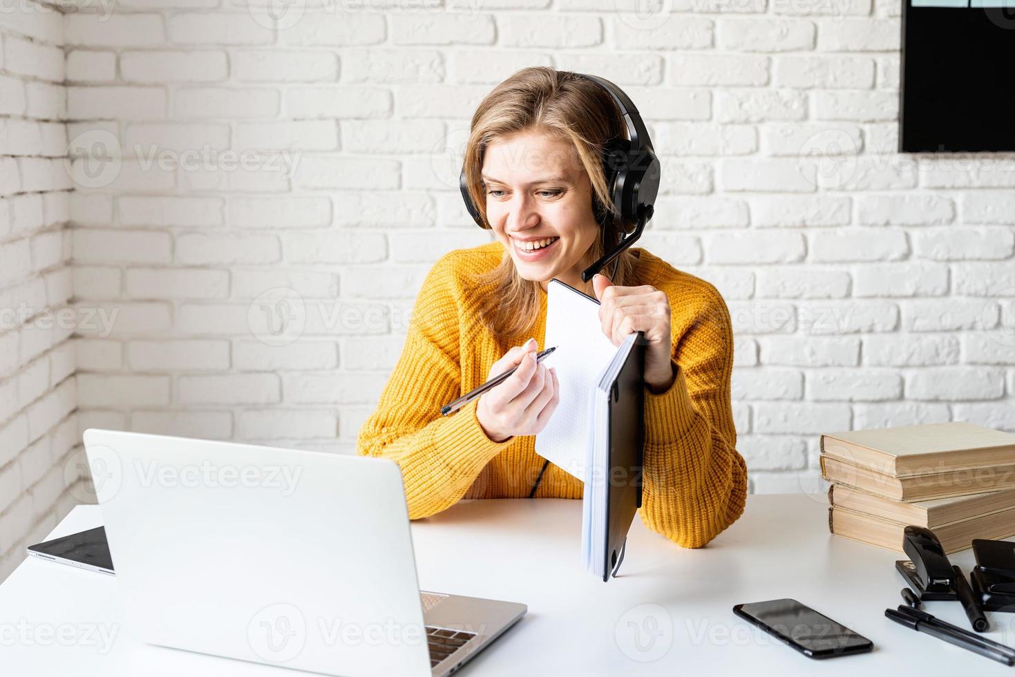 jovem com fones de ouvido pretos estudando on-line usando um laptop foto