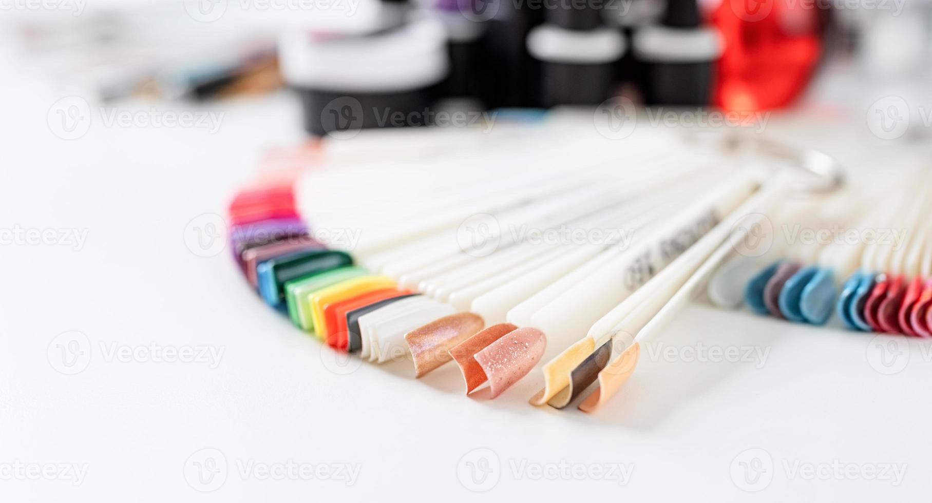 pontas de unhas de plástico coloridas em cima da mesa no salão de manicure foto