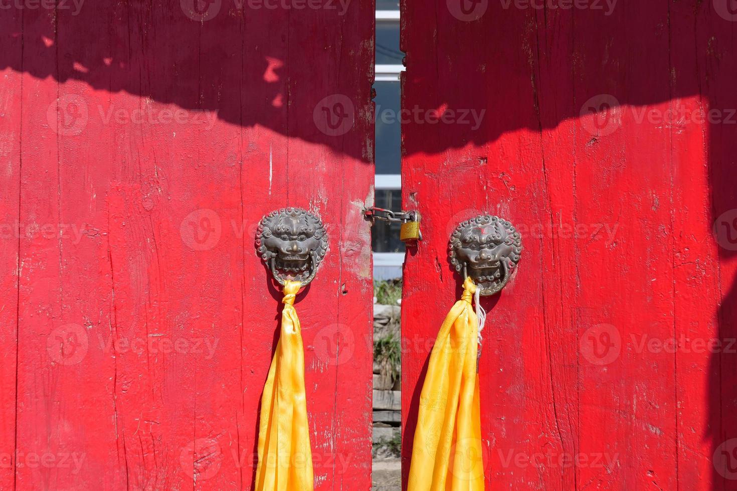 porta de madeira vermelha com argola de metal ao redor do templo em qinghai china. foto