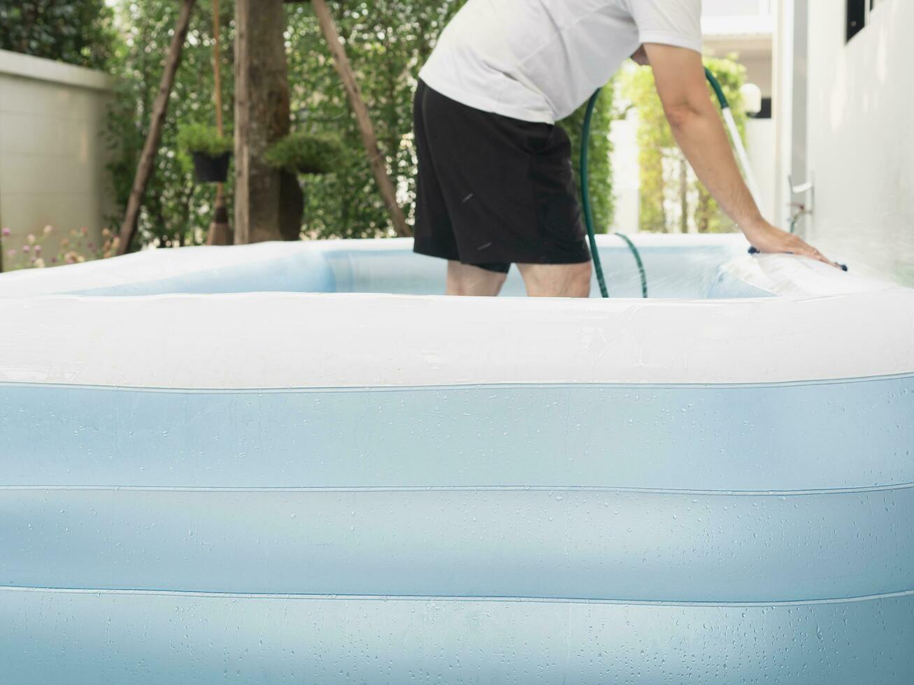 homem limpar \ limpo grande borracha brinquedo piscina - família estilo de vida jogar às casa atividade foto