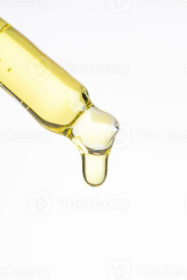 Cosmético pipeta com uma amarelo oleoso solta fechar acima em branco fundo ,macro foto