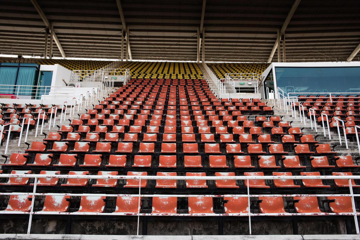 assentos de plástico vazios e velhos vermelhos no estádio. foto