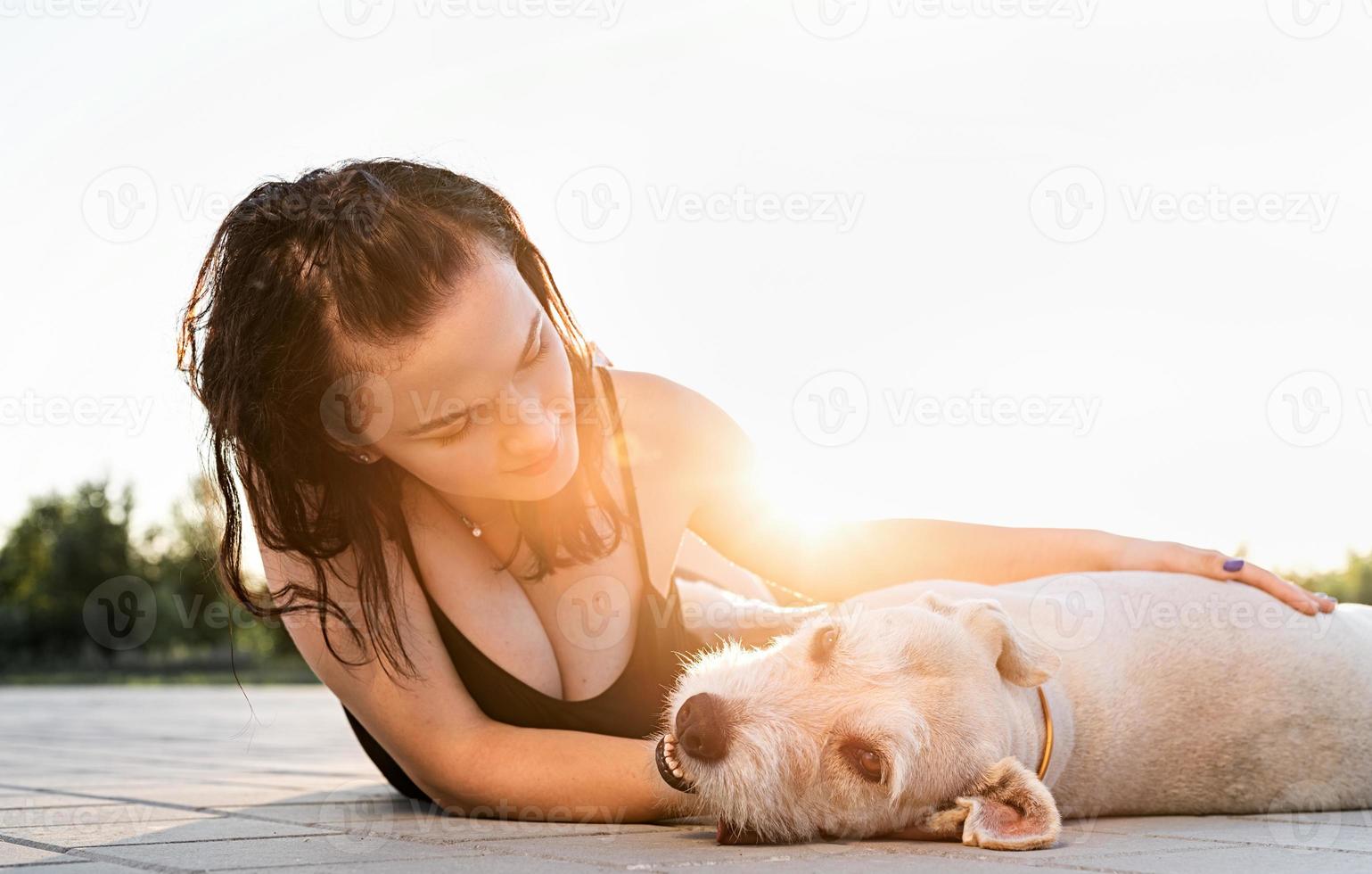 jovem mulher atraente abraçando seu cachorro no parque foto
