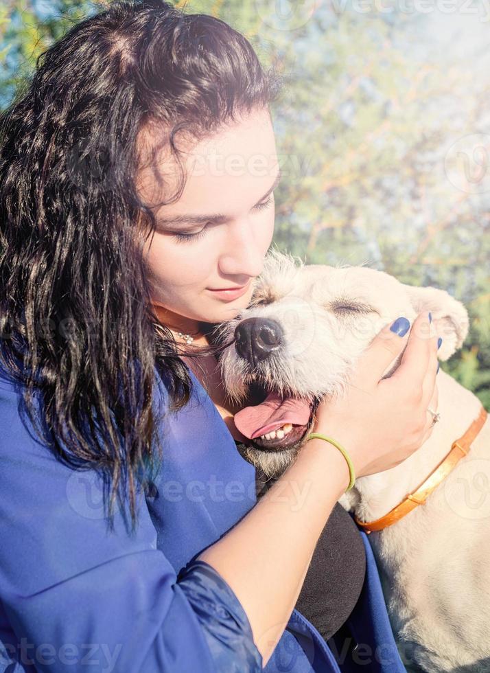 jovem abraçando seu cachorro no parque foto