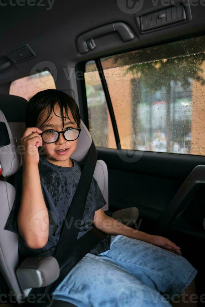 uma Garoto dentro uma carro pega molhado. foto