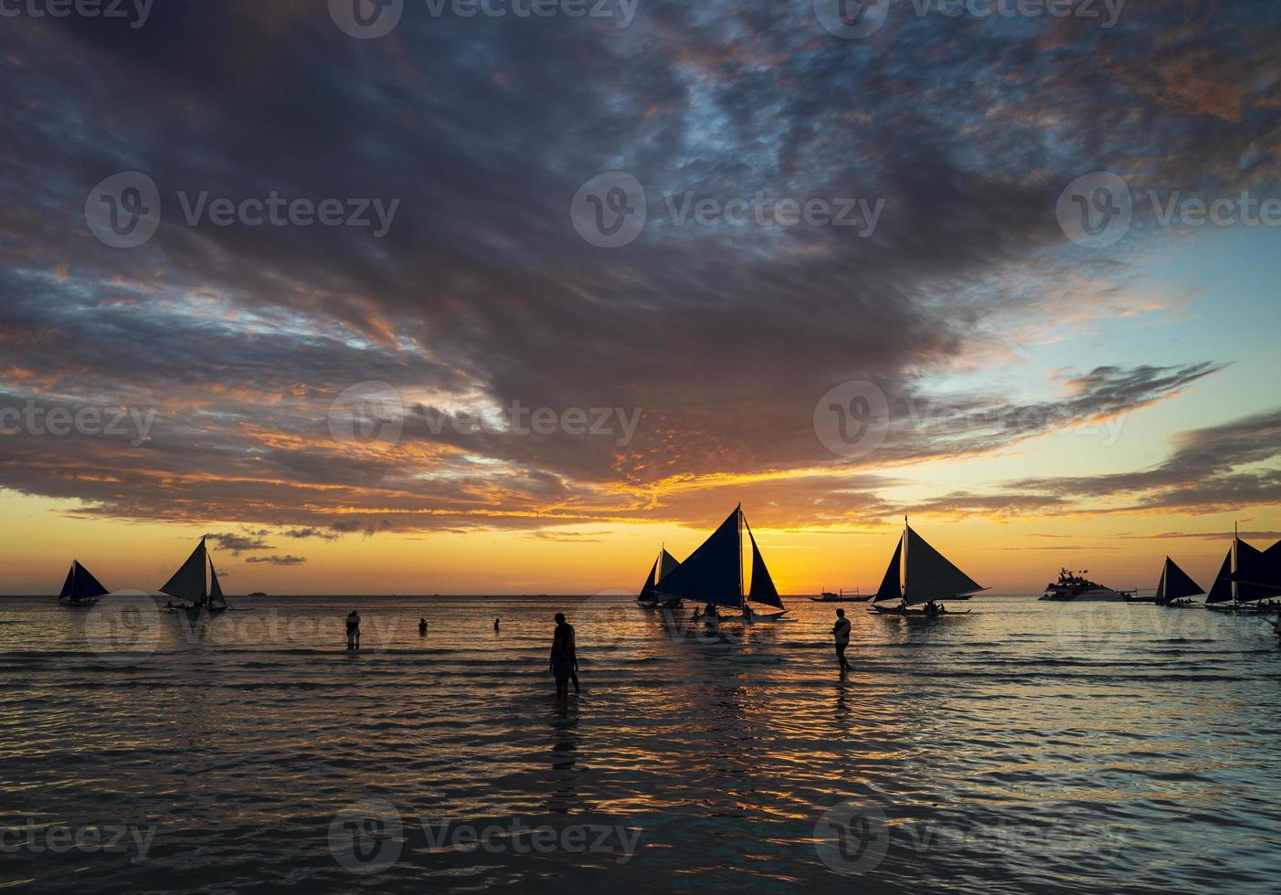 pôr do sol com barcos à vela e turistas na ilha de Boracay, nas Filipinas foto