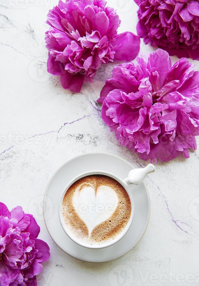 flores de peônia rosa e xícara de café foto
