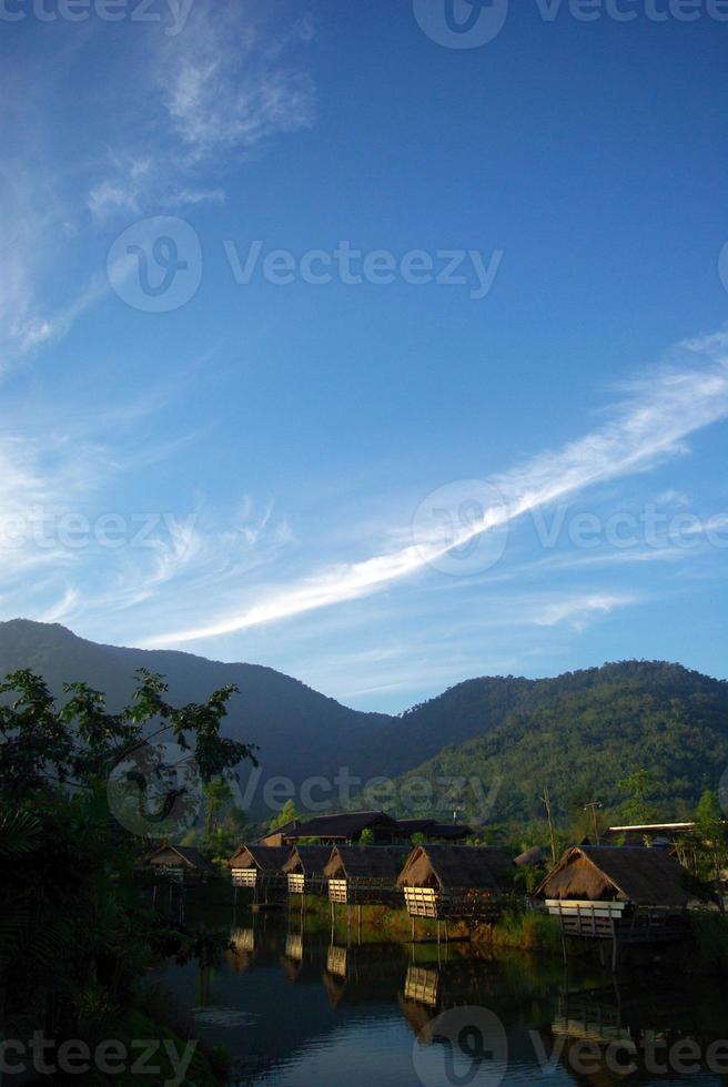 pela manhã, pequenas cabanas ao lado do lago e da vista da montanha foto