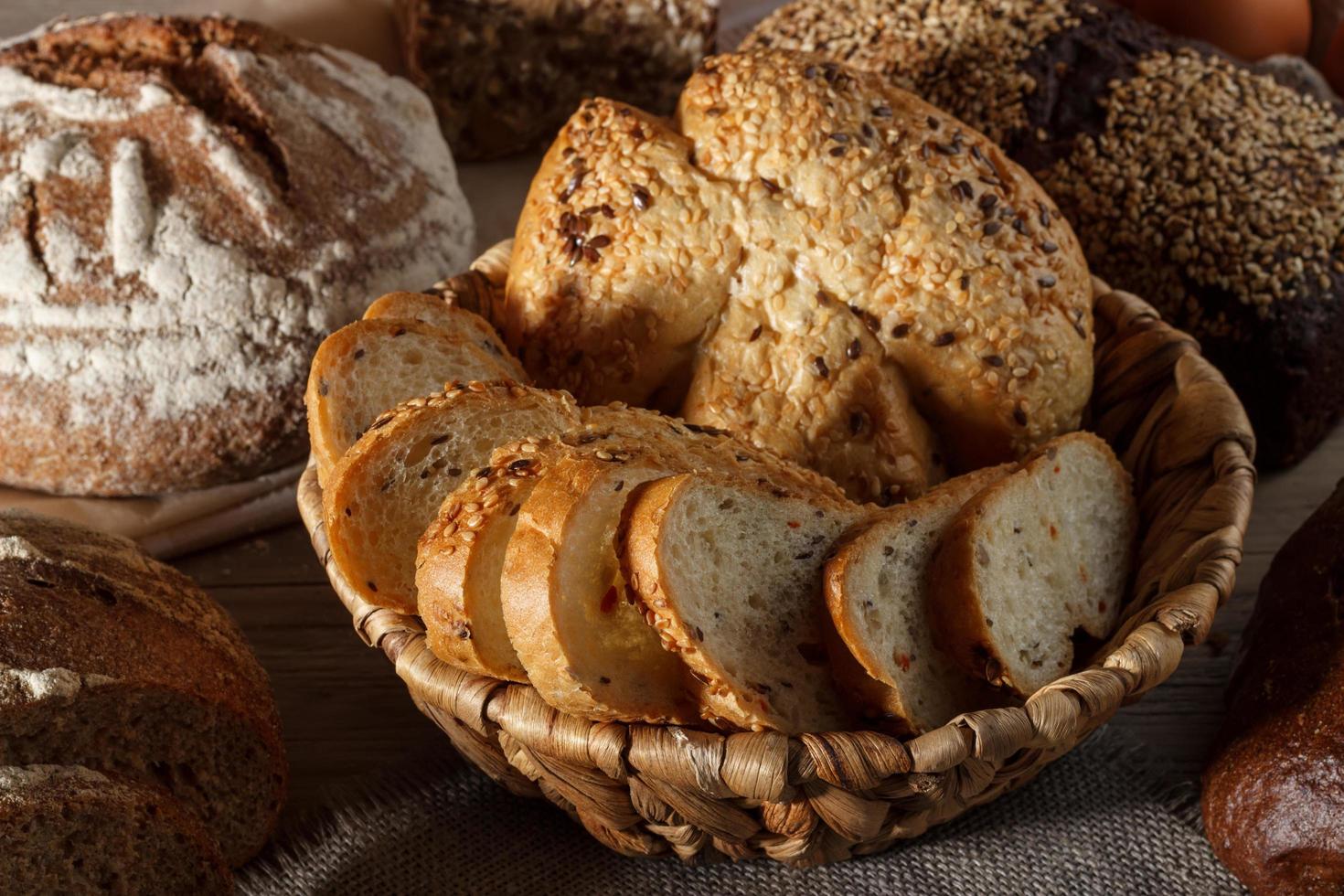 conjunto de pão de trigo e centeio com uma colher de sal em um fundo de madeira foto