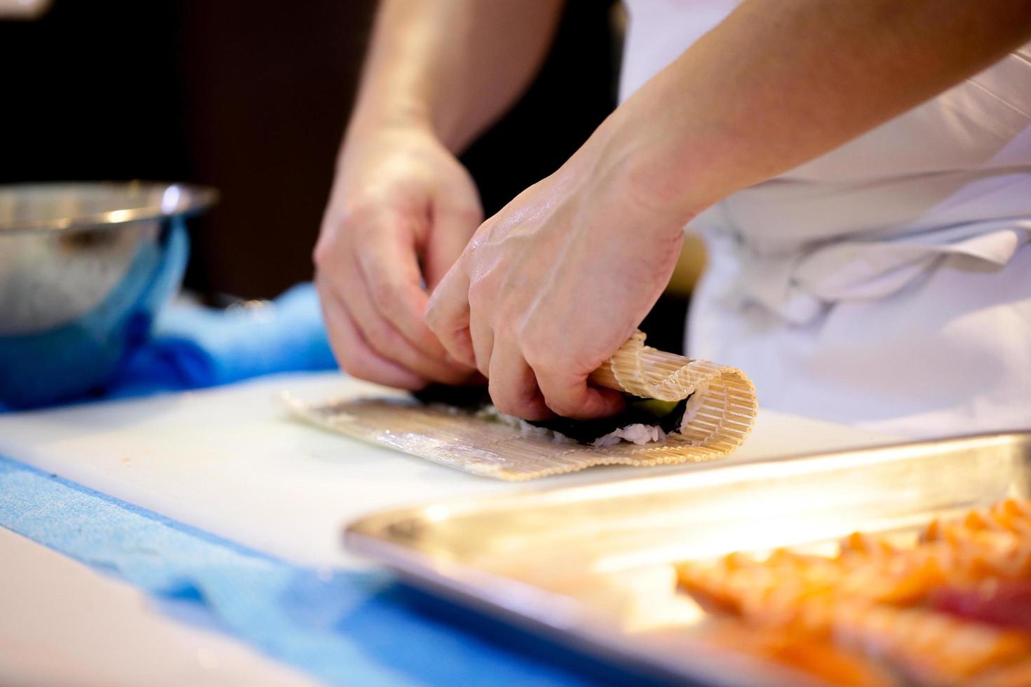 chef mãos preparando comida japonesa, chef fazendo sushi foto