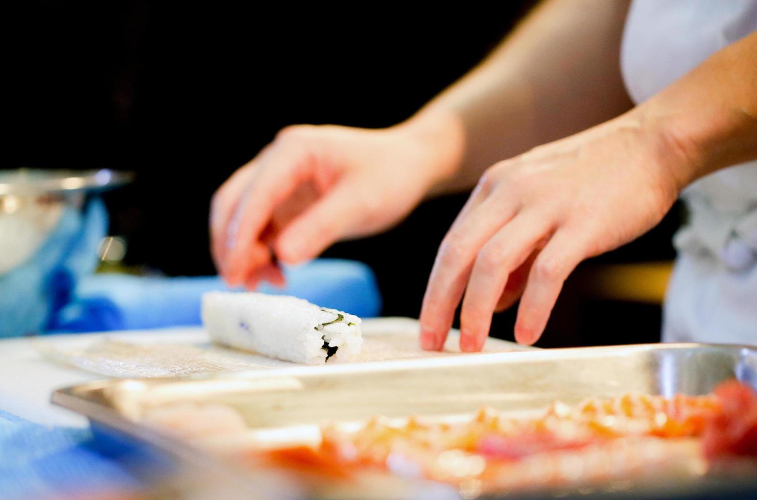 chef mãos preparando comida japonesa, chef fazendo sushi foto