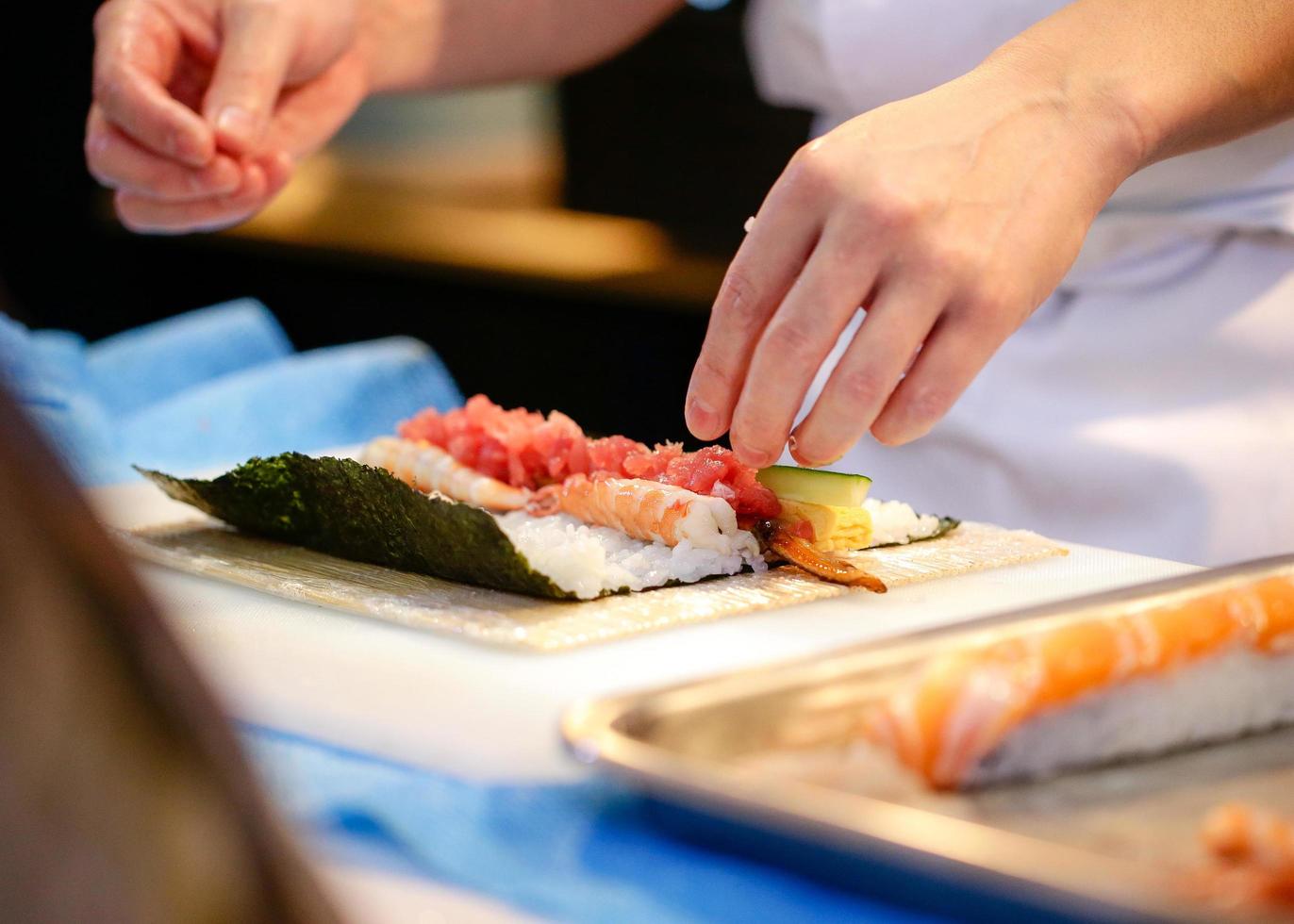 chef mãos preparando comida japonesa, chef fazendo sushi foto