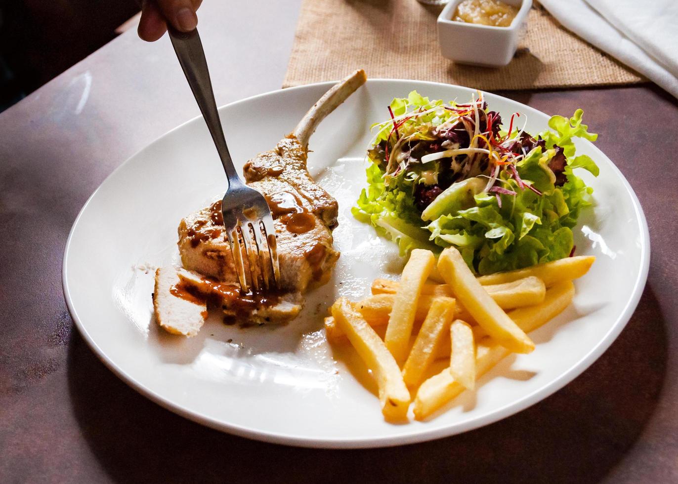 bife de porco com salada e batata frita foto