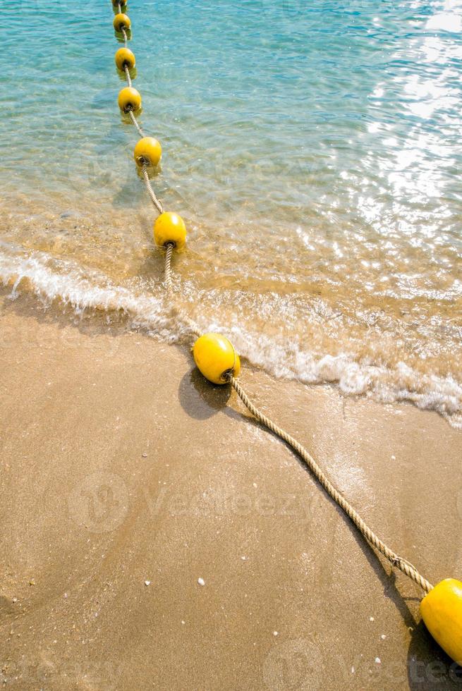 bóia flutuante e corda dividindo a área na praia foto