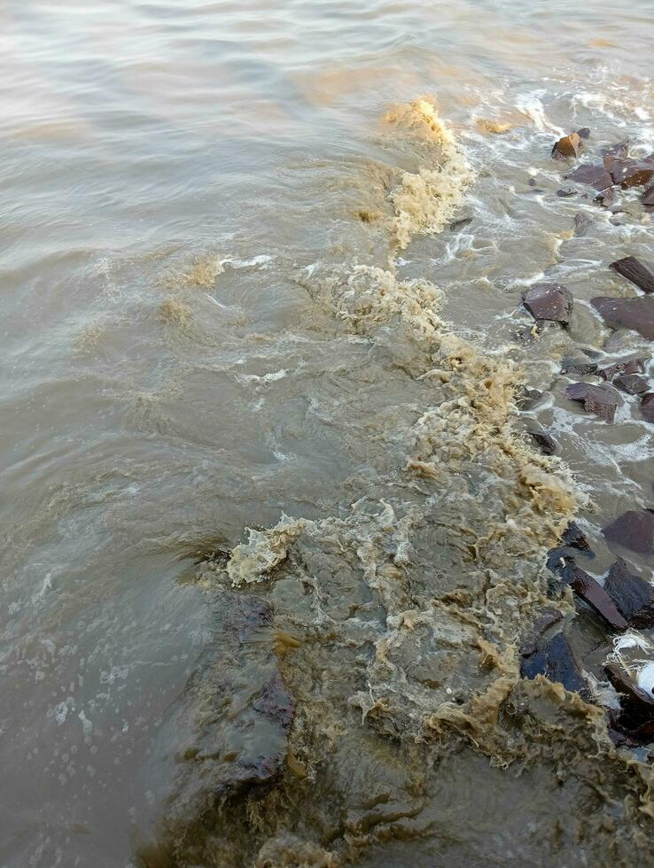 uma Castanho rio com pedras e água foto