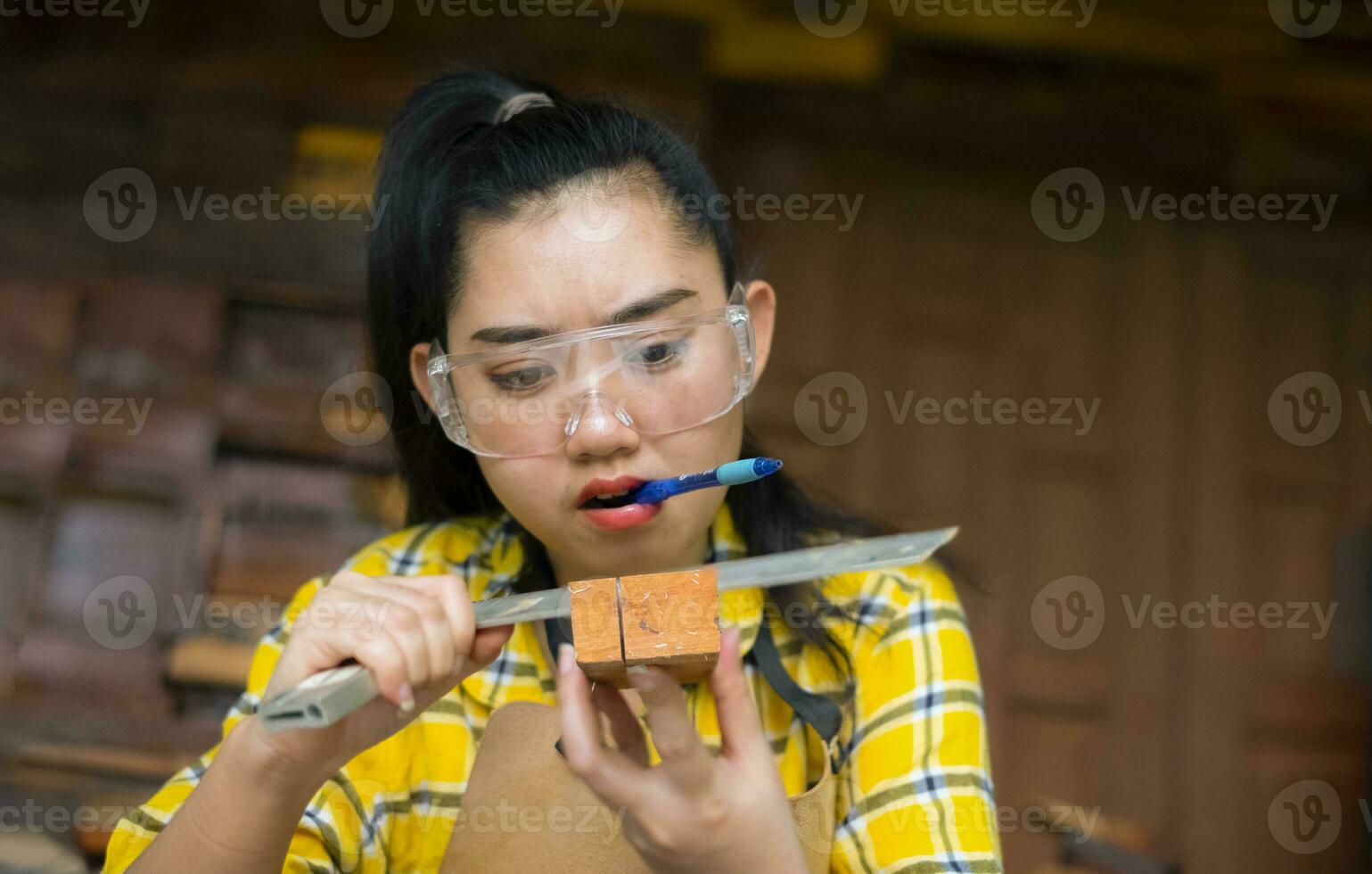 mulher segurando uma régua e um lápis enquanto faz marcas foto